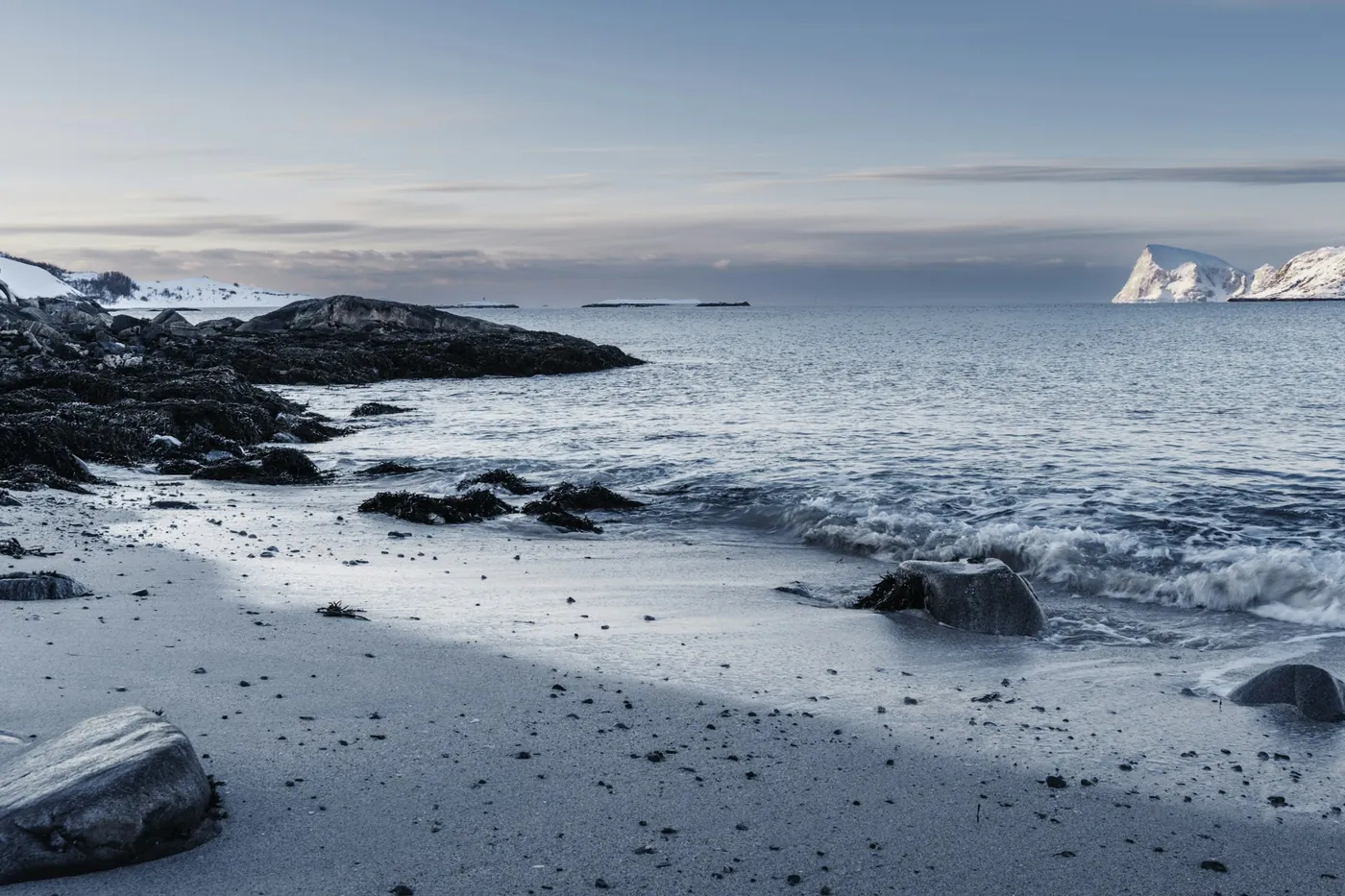 Snow-covered beach with rocks at the edge of the sea