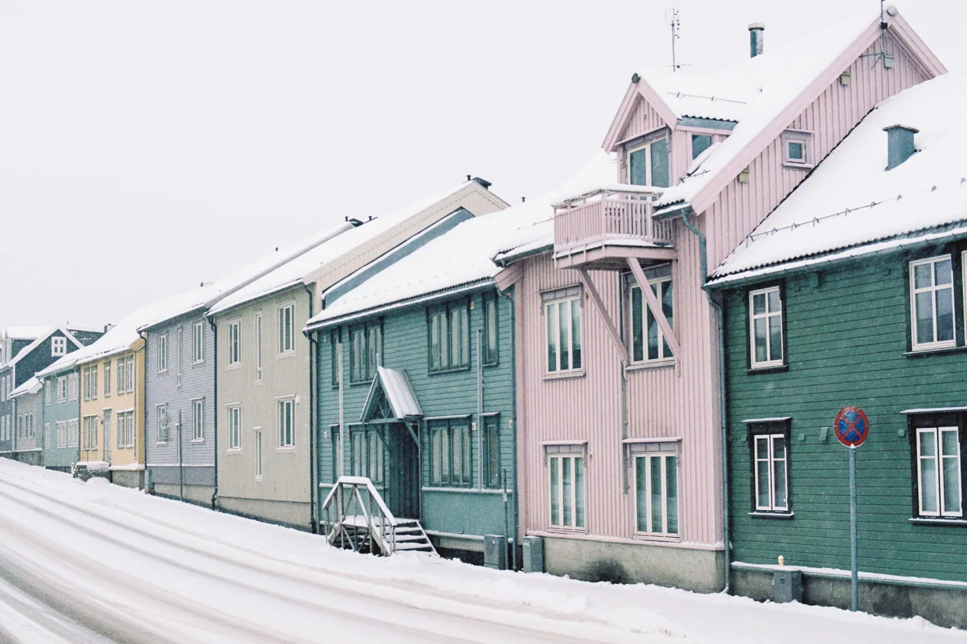 A row of colourful wooden houses in the snow