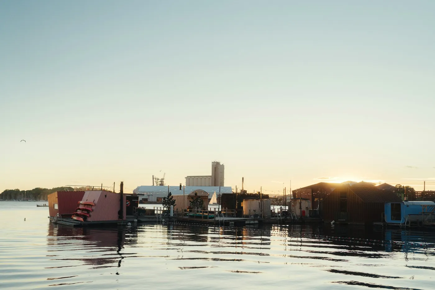 Floating sauna cabins on the water of a harbour in evening light
